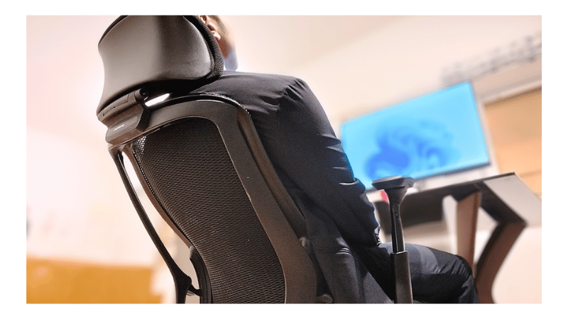 オカムラ シルフィーに浅くリクライニングして背中を預け、短時間だけ休憩している様子。深く倒れすぎない角度で姿勢をリセットし、作業効率を維持しやすい休息姿勢。