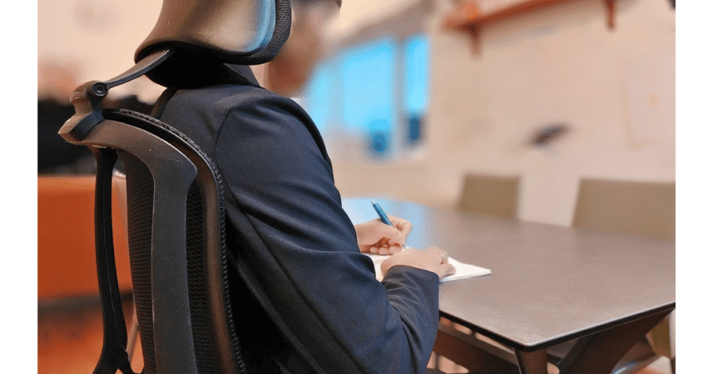 オカムラ シルフィーで前傾姿勢の書き物作業をしている様子(前傾ポジションの使用例)