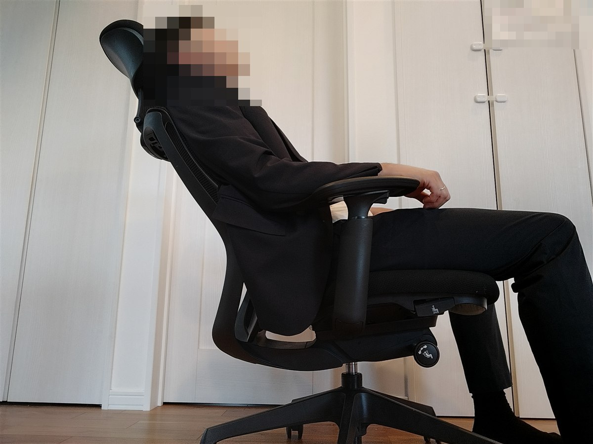 オカムラ シルフィーの可動ヘッドレストに頭を預けて、背もたれを浅く倒した横からの写真